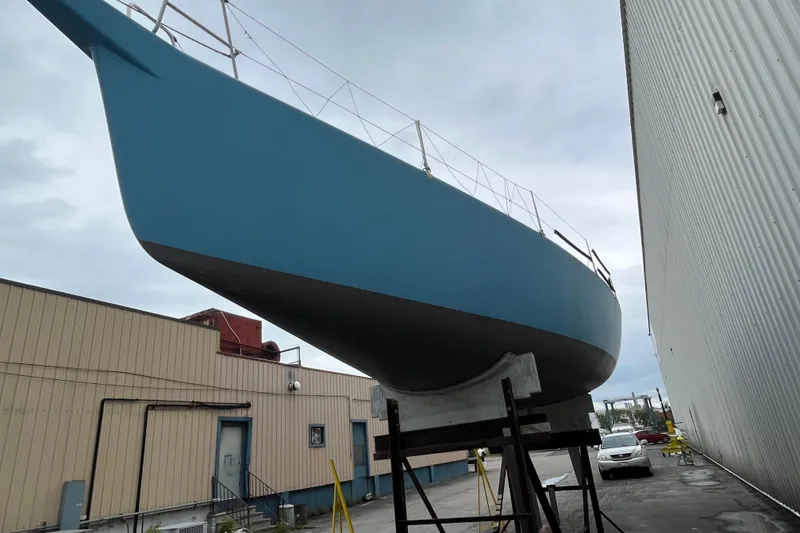 Slide: The Image of Blue 1994 Nelson Marek 43 sailboat on dry dock near industrial buildings. - 3