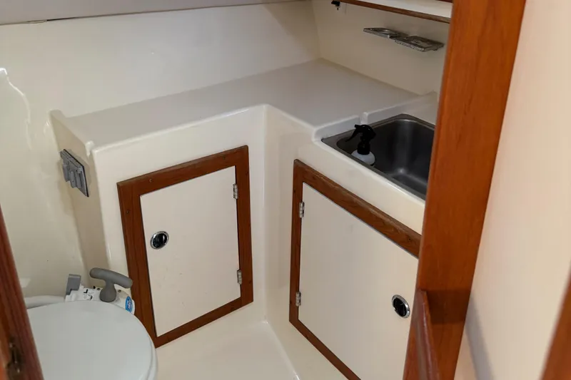 Slide: The Image of 1994 Albin 28 Tournament Express boat interior with sink, cabinets, and toilet. - 8