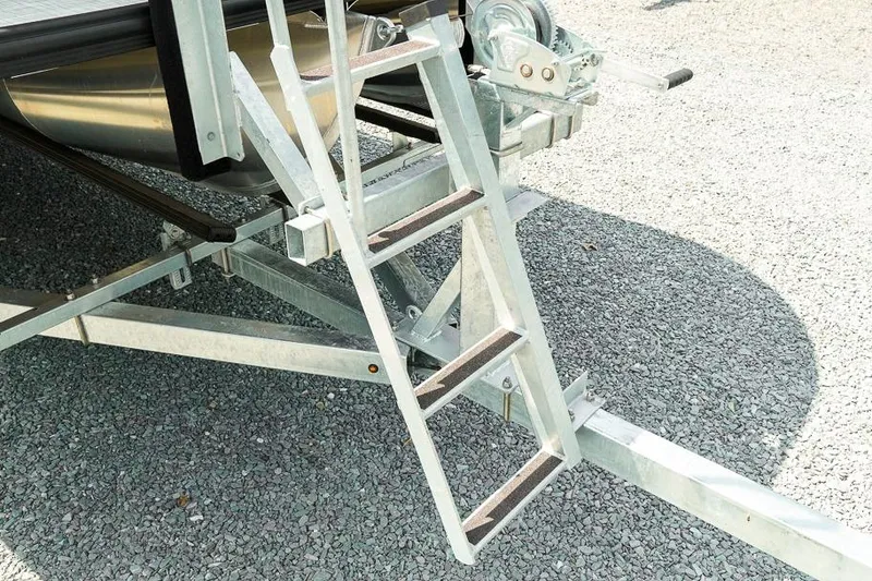 Slide: The Image of Aluminum ladder on Dockside Pontoons 22DQ trailer, 2026 model, on gravel surface. - 11