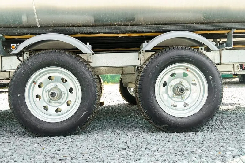 Slide: The Image of Trailer wheels of a 2026 Dockside Pontoons 22DQ on gravel surface. - 34