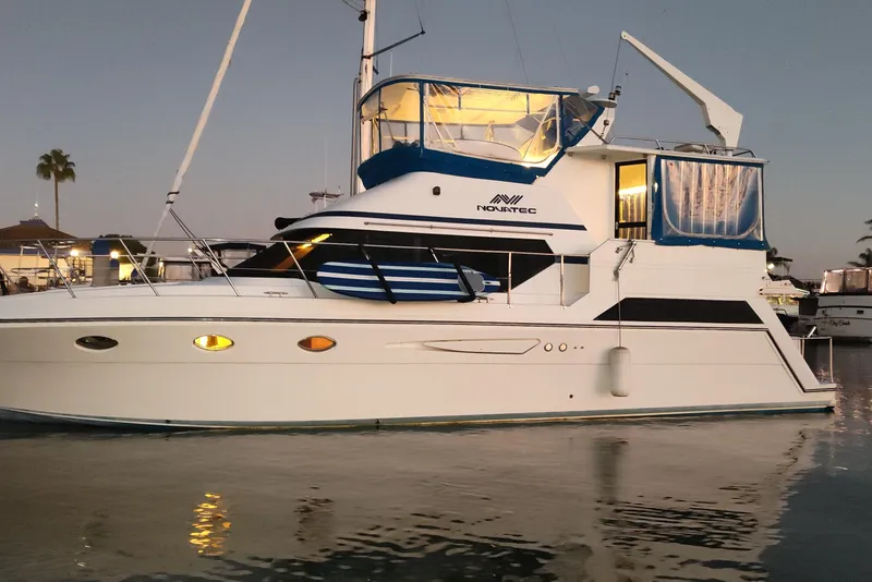 The Image of Luxury 1993 Novatec 44 yacht docked at sunset, featuring elegant design and illuminated interior. - 0