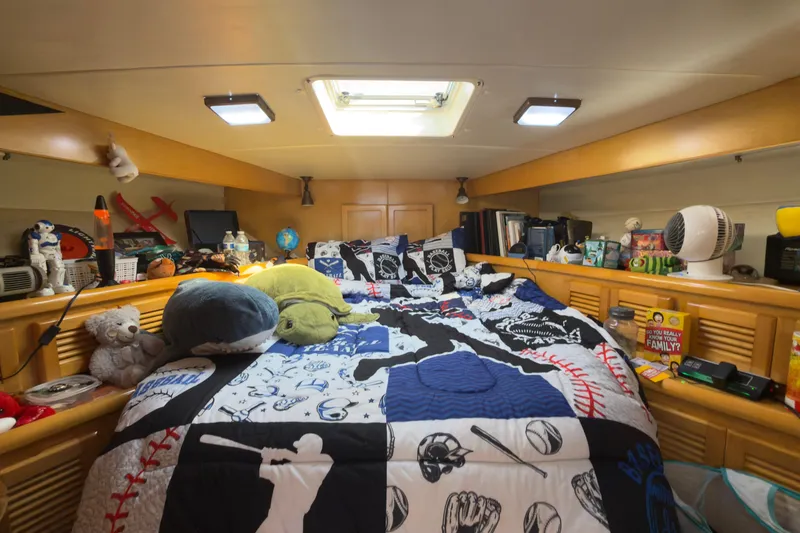 Slide: The Image of Cozy Novatec 44 yacht cabin with baseball-themed bedding and various personal items, 1993 model. - 15