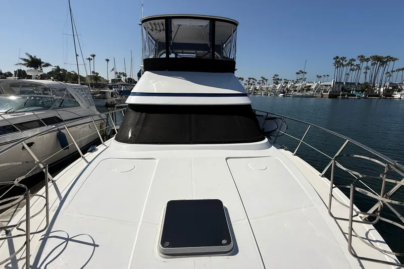 Slide: The Image of Novatec 44 yacht from 1993 docked in a marina, clear sky, palm trees visible. - 2