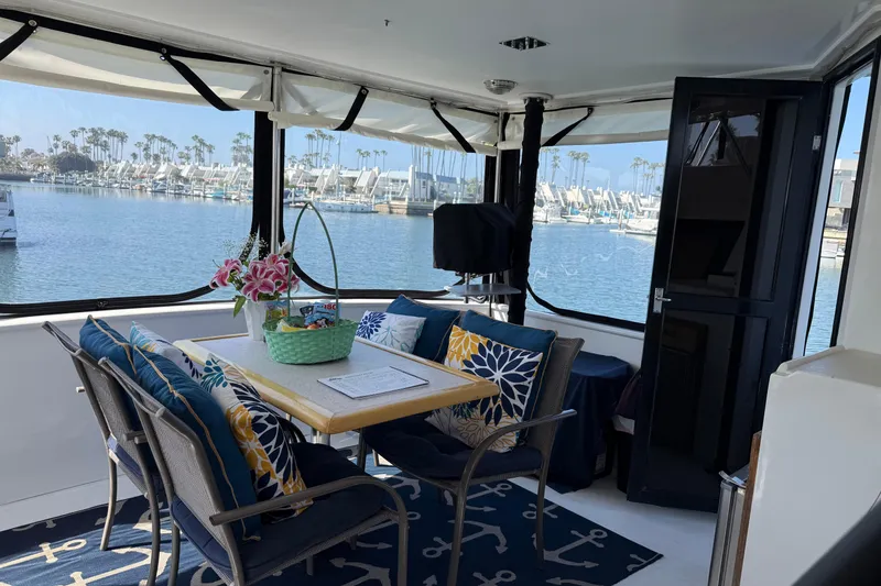 Slide: The Image of Cozy interior of 1993 Novatec 44 yacht with marina view, featuring a dining area and decorative pillows. - 5
