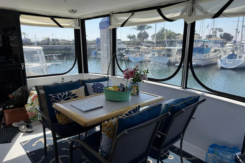 Slide: The Image of Cozy interior of 1993 Novatec 44 yacht with marina view, featuring a dining area and floral decor. - 6