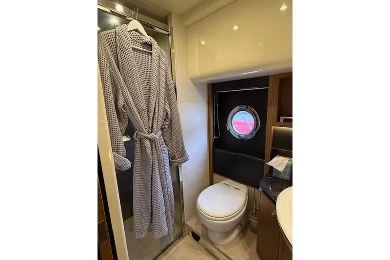 Slide: The Image of Luxurious bathroom on 2018 Absolute Navetta 52 yacht with robe and porthole window. - 17