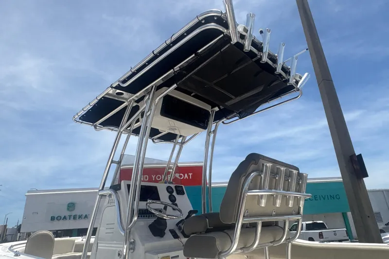 Slide: The Image of 2024 Key West 219 FS boat with T-top and helm station under clear sky. - 6