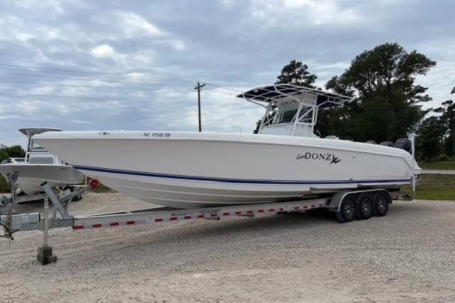 The Image of 2007 Donzi 38 ZF Open boat on a trailer, parked outdoors under cloudy skies. - 0
