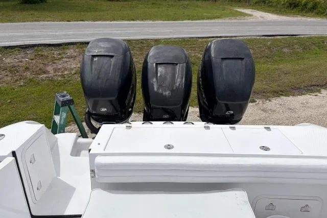 Slide: The Image of 2007 Donzi 38 ZF Open with triple outboard engines, parked on a grassy area. - 12