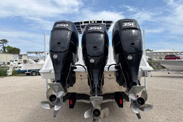 Slide: The Image of Triple outboard engines on a 2007 Donzi 38 ZF Open boat, parked on gravel. - 13
