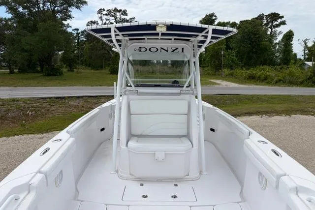 Slide: The Image of 2007 Donzi 38 ZF Open boat with white seating and canopy, parked on gravel. - 22