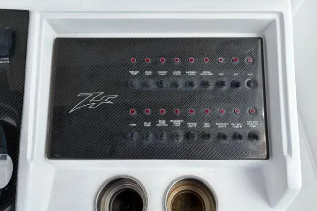 Slide: The Image of Control panel of a 2007 Donzi 38 ZF Open boat with switches and cup holders. - 31