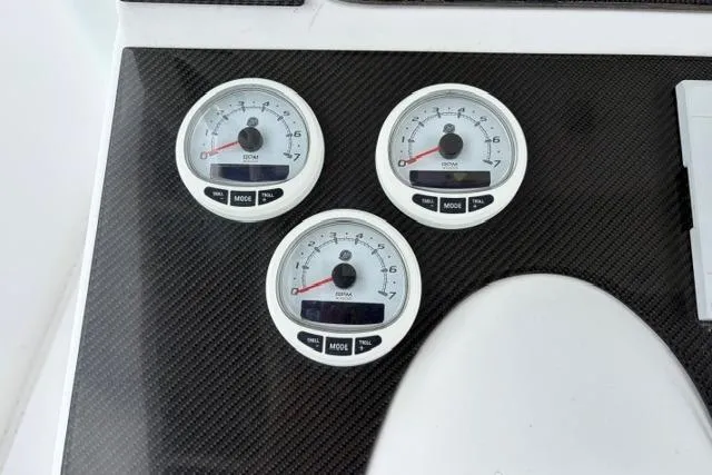 Slide: The Image of Dashboard gauges on a 2007 Donzi 38 ZF Open boat, featuring carbon fiber paneling. - 32