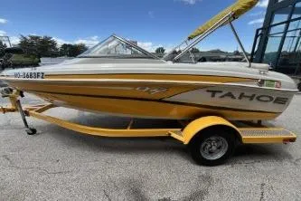 Slide: The Image of 2013 Tahoe Q4 SF boat with yellow trailer, parked outdoors. - 10