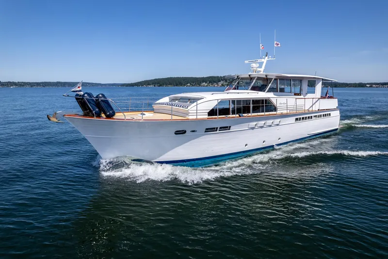 The Image of 1965 Chris-Craft 57 Constellation yacht cruising on open water under clear blue skies. - 0