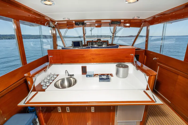 Slide: The Image of 1965 Chris-Craft 57 Constellation yacht interior with wooden cabinetry and ocean view. - 19