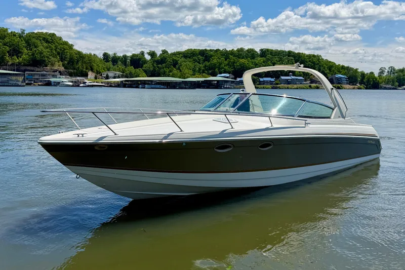 Slide: The Image of 2003 Formula 330 Sun Sport boat on a serene lake with lush green shoreline. - 10