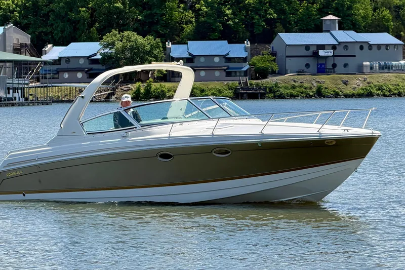 Slide: The Image of 2003 Formula 330 Sun Sport boat cruising on a calm river near a scenic shoreline. - 11