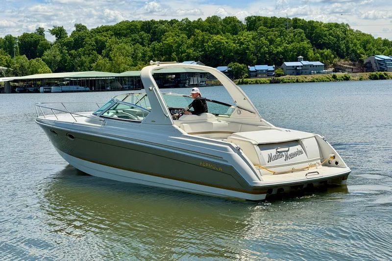 Slide: The Image of 2003 Formula 330 Sun Sport boat cruising on a serene lake with lush green shoreline. - 3