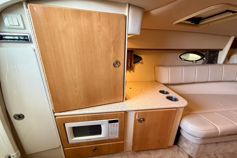 Slide: The Image of 2003 Formula 330 Sun Sport cabin interior with microwave, wooden cabinetry, and seating area. - 32