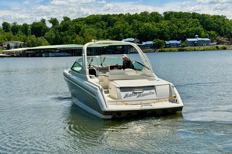 Slide: The Image of 2003 Formula 330 Sun Sport boat cruising on a serene lake with lush green shoreline. - 4