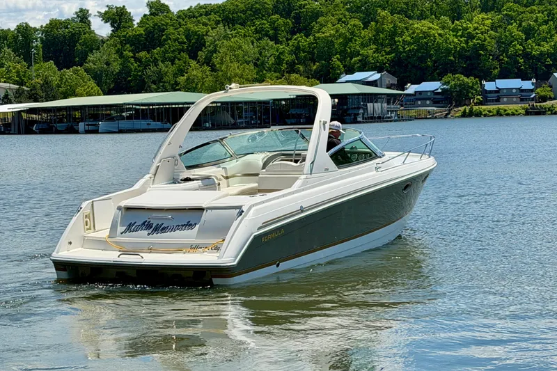 Slide: The Image of 2003 Formula 330 Sun Sport boat cruising on a scenic lake with lush greenery. - 5