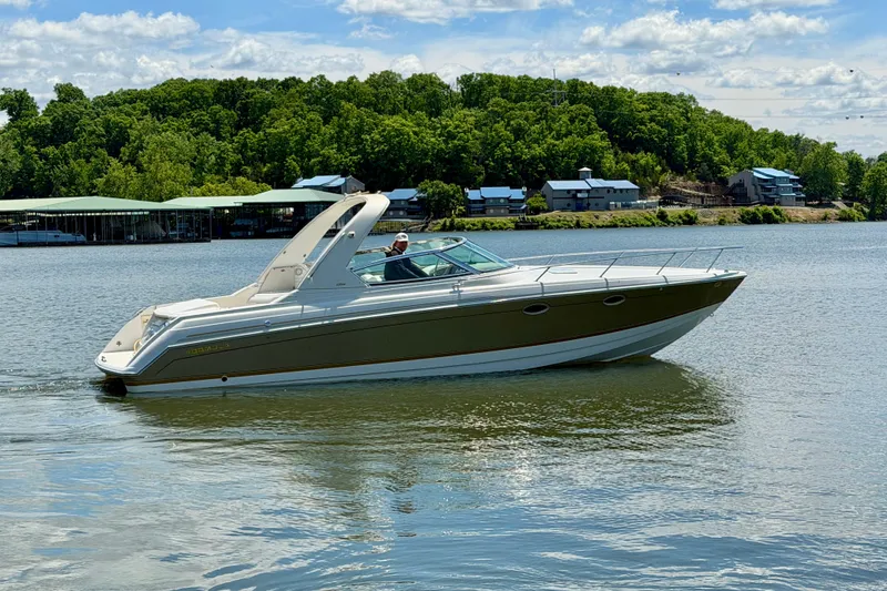 Slide: The Image of 2003 Formula 330 Sun Sport boat cruising on a scenic lake with lush green shoreline. - 7