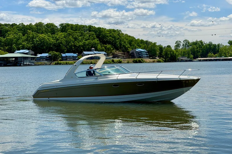 Slide: The Image of 2003 Formula 330 Sun Sport boat cruising on a scenic lake with lush green shoreline. - 8