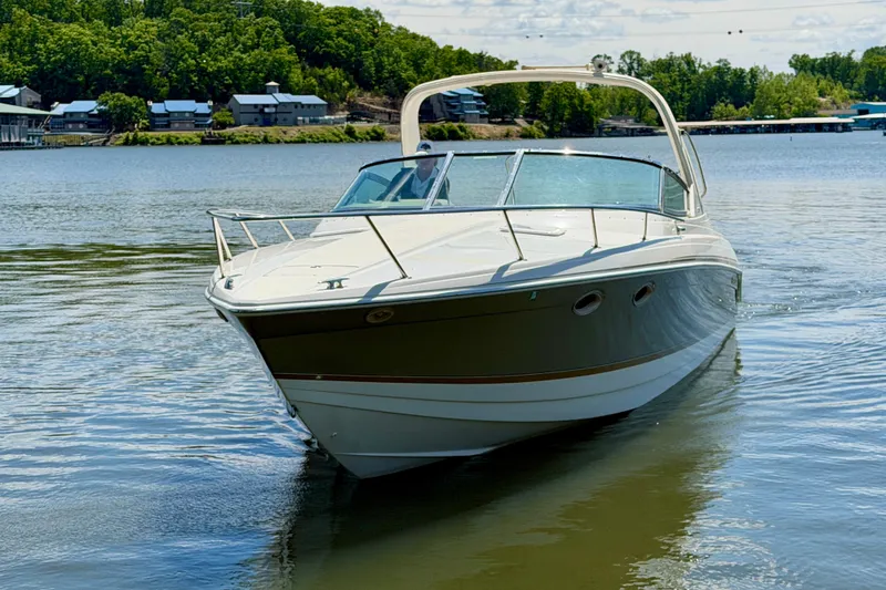 Slide: The Image of 2003 Formula 330 Sun Sport boat cruising on a serene lake with lush green shoreline. - 9