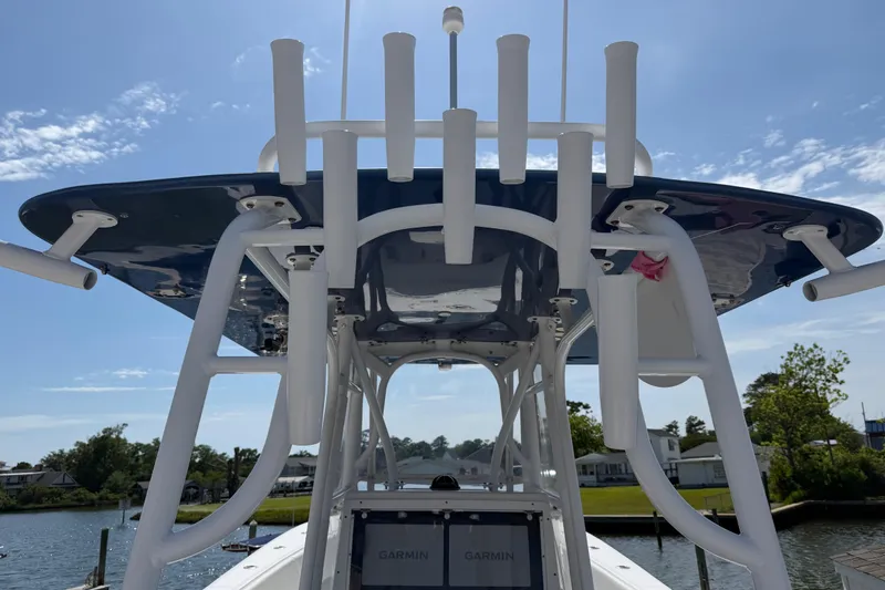 Slide: The Image of 2021 Competition 31 boat with rod holders and Garmin electronics, docked by a scenic waterfront. - 18