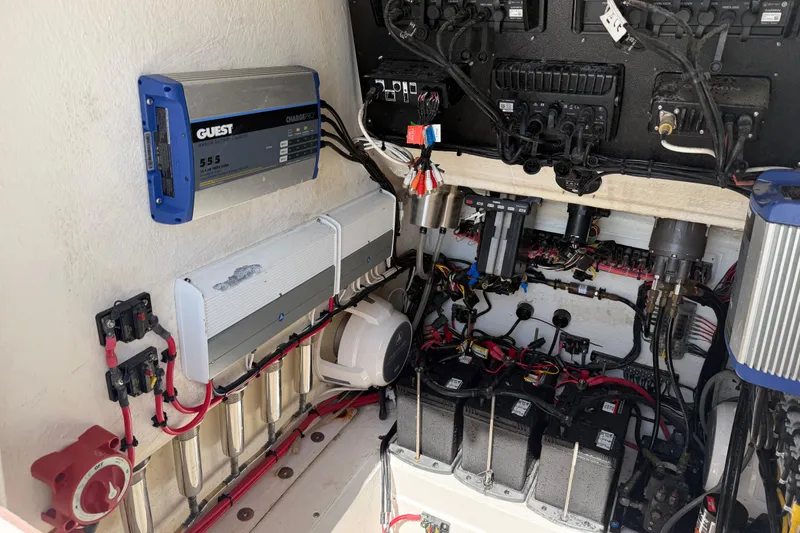 Slide: The Image of Electrical system setup in a 2021 Competition 31 boat, featuring battery chargers and wiring. - 27