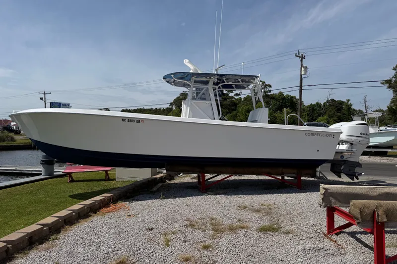 Slide: The Image of 2021 Competition 31 boat on display, white hull, dual outboard motors, sunny day. - 4