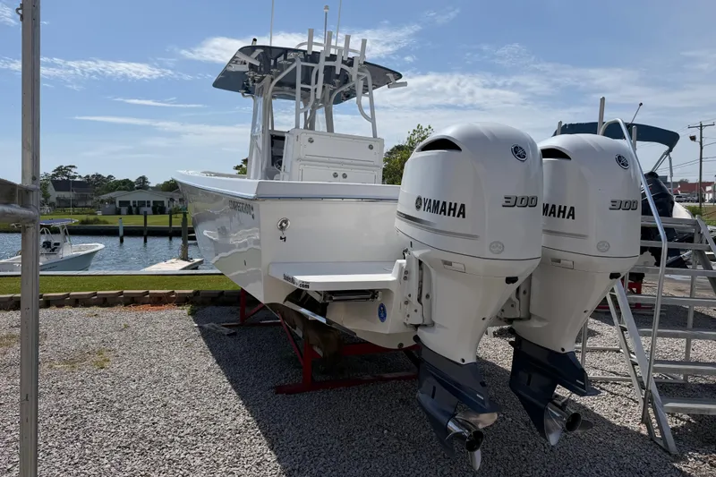 Slide: The Image of 2021 Competition 31 boat with twin Yamaha 300 engines docked on gravel. - 6