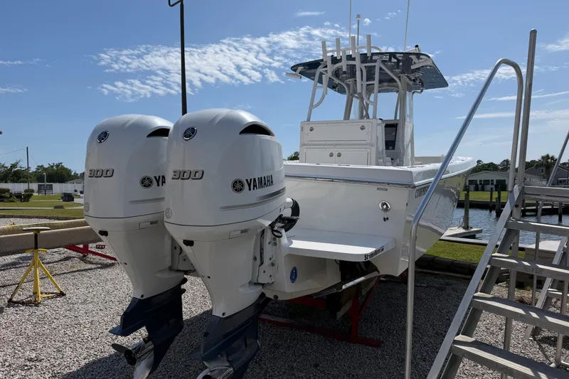 Slide: The Image of 2021 Competition 31 boat with twin Yamaha 300 engines, docked on gravel. - 7
