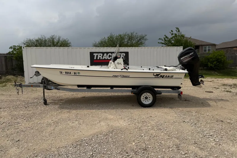The Image of 2015 Mako Pro Skiff 17 CC boat on trailer, parked outdoors with cloudy sky. - 0