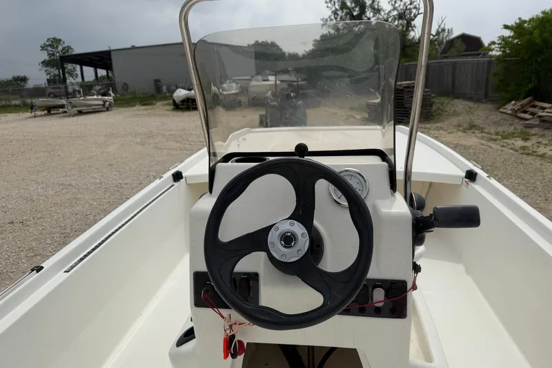 Slide: The Image of 2015 Mako Pro Skiff 17 CC boat dashboard with steering wheel and controls. - 10