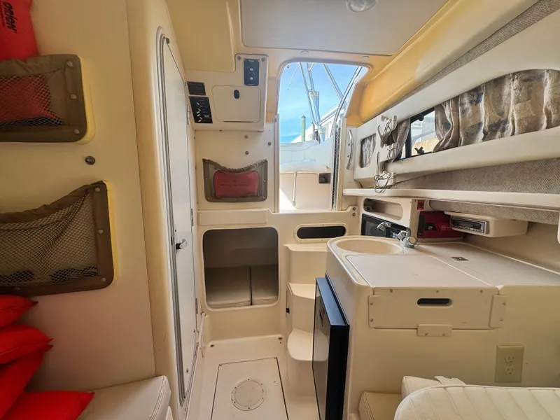 Slide: The Image of Interior of a 2002 Grady-White Sailfish 282 boat, featuring kitchenette and storage. - 12