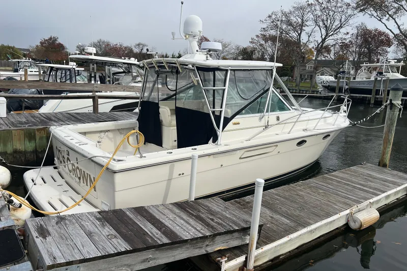 The Image of 1993 Tiara Yachts 3100 Open docked at marina, featuring sleek design and spacious deck. - 0