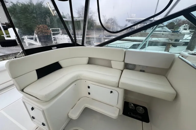 Slide: The Image of 1993 Tiara Yachts 3100 Open interior seating area with white cushions and clear windows. - 10