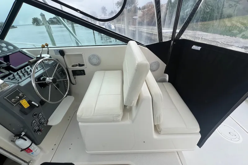 Slide: The Image of 1993 Tiara Yachts 3100 Open helm with steering wheel and white seating. - 11