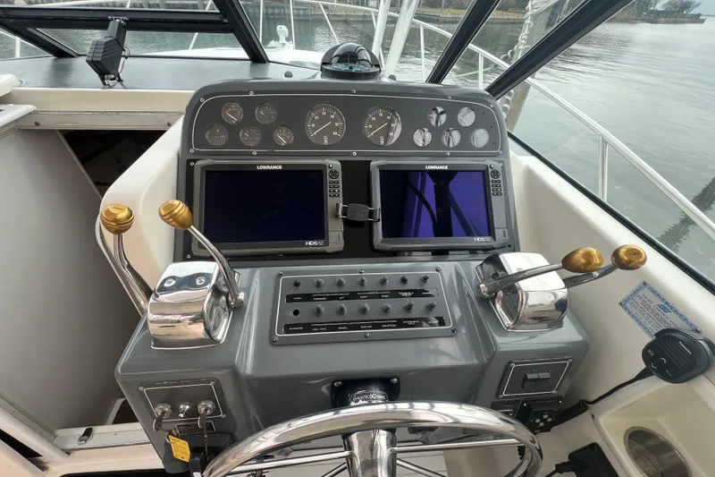 Slide: The Image of Cockpit of 1993 Tiara Yachts 3100 Open with navigation controls and dual Lowrance displays. - 12