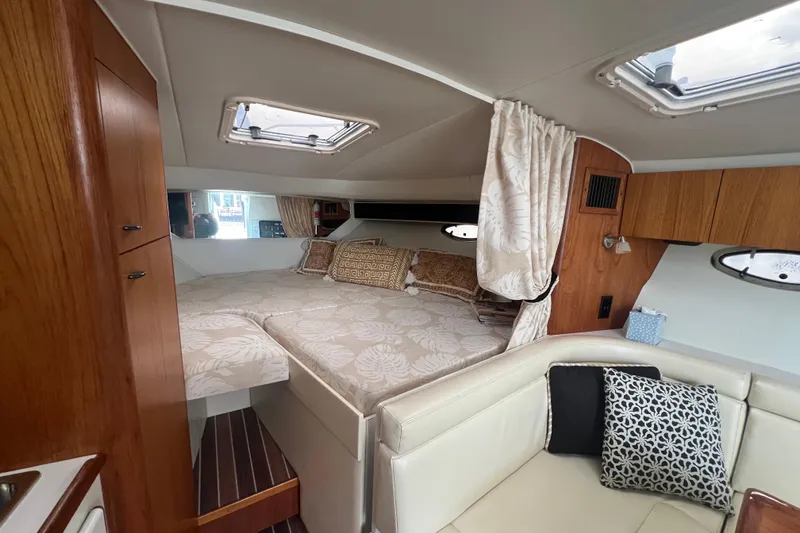 Slide: The Image of 1993 Tiara Yachts 3100 Open cabin interior with bed, cushions, and wooden cabinetry. - 16