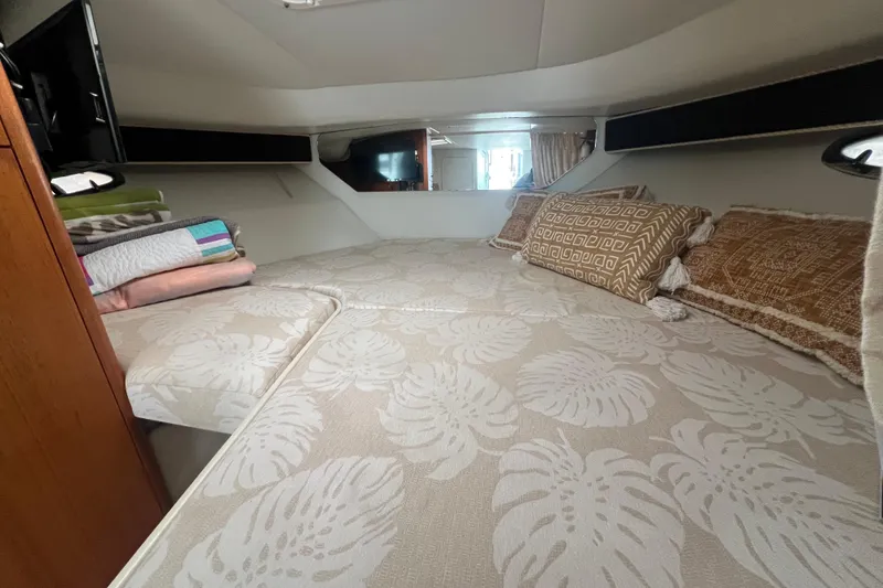 Slide: The Image of Cozy cabin interior of 1993 Tiara Yachts 3100 Open with patterned bedding and pillows. - 17