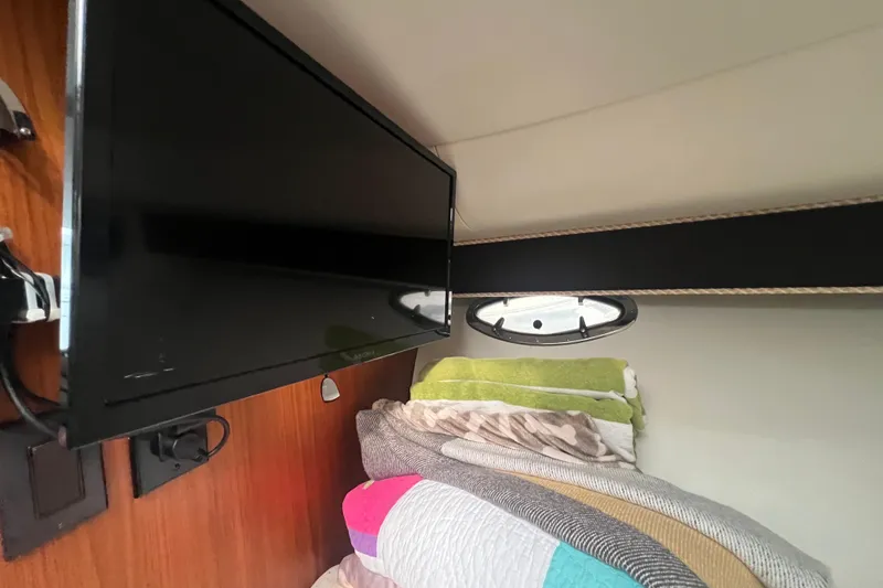 Slide: The Image of Interior of 1993 Tiara Yachts 3100 Open with TV and cozy bedding. - 18