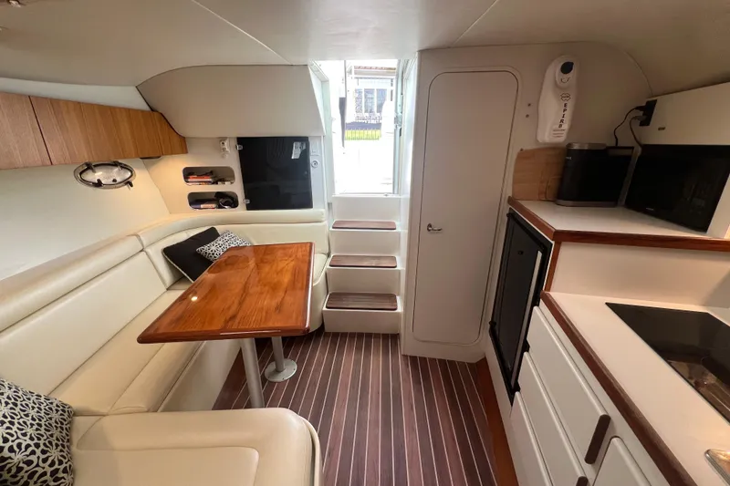 Slide: The Image of Interior of 1993 Tiara Yachts 3100 Open, featuring cozy seating and wooden table. - 20