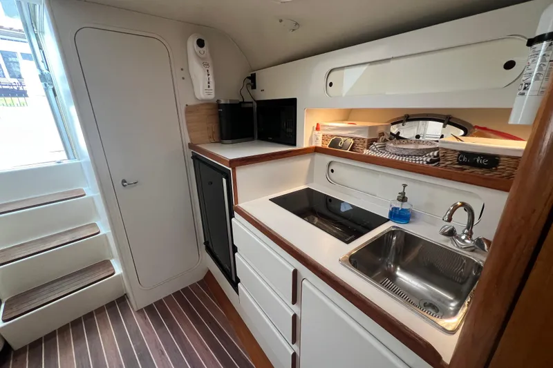 Slide: The Image of 1993 Tiara Yachts 3100 Open interior kitchen with sink, stove, and storage. - 21