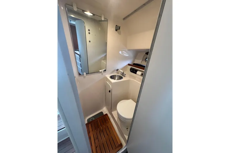 Slide: The Image of Compact bathroom in 1993 Tiara Yachts 3100 Open, featuring sink, toilet, and mirror. - 24