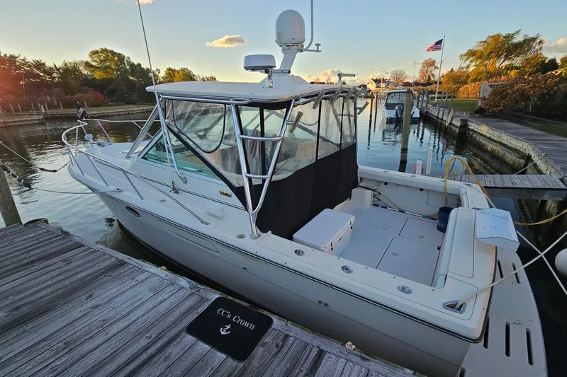 Slide: The Image of 1993 Tiara Yachts 3100 Open docked at a serene marina, showcasing sleek design. - 34