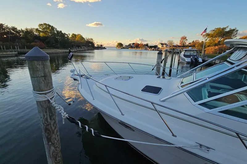 Slide: The Image of 1993 Tiara Yachts 3100 Open docked in a serene marina at sunset. - 35