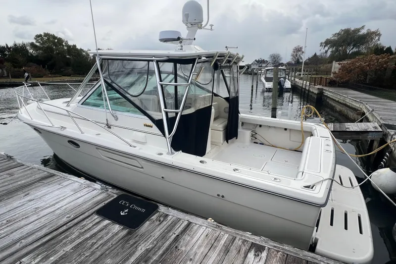 Slide: The Image of 1993 Tiara Yachts 3100 Open docked at a marina, featuring a sleek white design. - 6